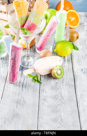 Bunte Fruchteis Popsicle. Saftige gelato Lutscher auf Stöcke, mit verschiedenen frischen tropischen Früchte, Holz- Background Copy space Stockfoto