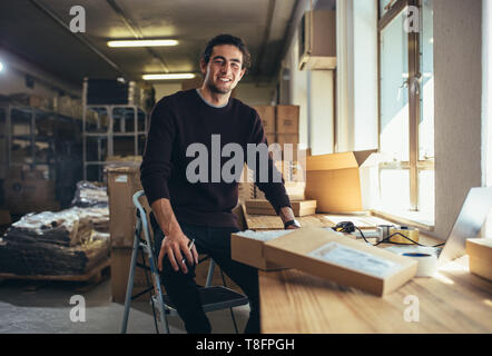 Zuversichtlich, dass junge Unternehmer an Online Business Store funktioniert. Inhaber kleiner Unternehmen an seinem Schreibtisch. Stockfoto