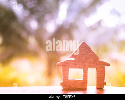 Holz Modell auf den Schreibtisch stellen, Darlehen für Immobilien oder für ein neues Haus Konzept kaufen, blur Natur Hintergrund Stockfoto