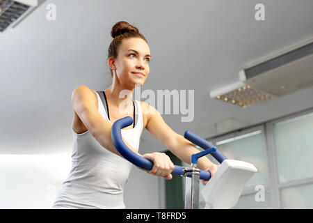 Training auf einem stationären Fahrrad. Eine junge Frau mit dem Fahrrad in einem Fitness Club. Stockfoto