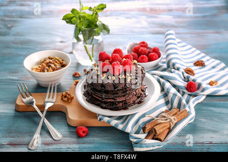 Zusammensetzung mit leckeren Schokolade Pfannkuchen und Beeren auf hölzernen Tisch Stockfoto