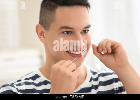 Junger Mann Zähne zu Hause flossing Stockfoto