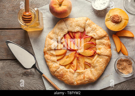 Pergament mit köstlichen Pfirsich Galette auf Tisch Stockfoto