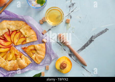 Pergament mit köstlichen Pfirsich Galette auf Licht Tabelle Stockfoto