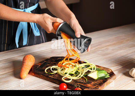 Frau, die Zucchini und Karotten Spaghetti Stockfoto
