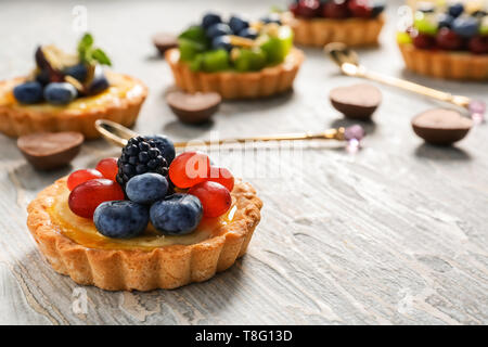 Leckere Törtchen mit Beeren auf hölzernen Tisch Stockfoto