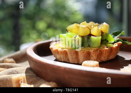 Köstliche Kuchen mit Früchten auf Platte Stockfoto