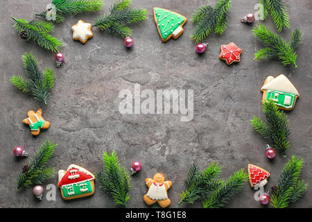 Das Gestell ist mit Tannenbaum, Zweige und Weihnachtsplätzchen auf grauem Hintergrund Stockfoto