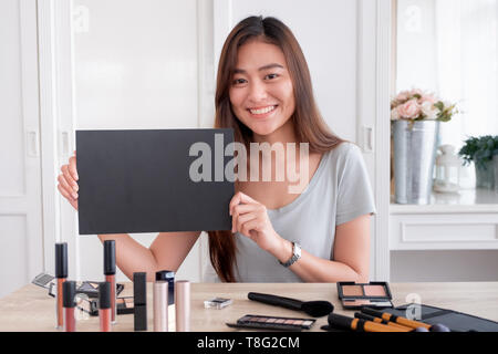 Asiatische junge weibliche blogger Werbegeschenk Geschenk fan folgenden Kanal während der Aufnahme vlog Video mit Make-up Kosmetik zu Hause online Einflussnehmer Konzept. live Stockfoto