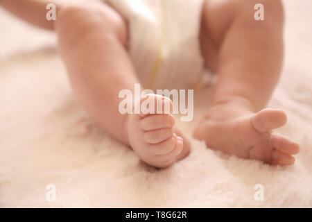 Beine von niedlichen kleinen Baby liegend auf Bett Stockfoto