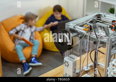 Kleine Jungs warten auf Lehrer in Stuhl Taschen, während im Labor sitzen Stockfoto