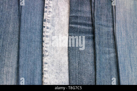 Stapel mit verschiedenen Schattierungen von Jeans als Hintergrund Stockfoto