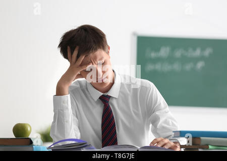 Müde Teenager an Lektion im Klassenzimmer Stockfoto