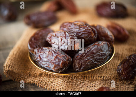 Ramadan Essen und Getränke Konzept. Termine Obst in einer Schüssel auf hölzernen Tisch Hintergrund. Stockfoto