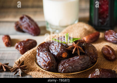 Ramadan Essen und Getränke Konzept. Ramadan Termine Laterne mit Milch, Früchte und grüner Minze in einer Schüssel auf hölzernen Tisch Hintergrund bleibt. Stockfoto