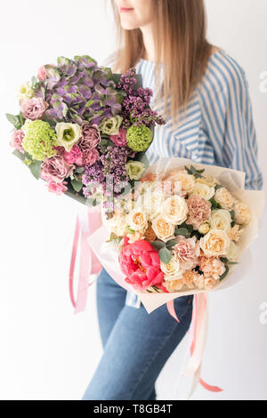 Zwei schöne Sträuße Gemischte Blumen in womans Hände. Die Arbeit der Florist in einem Blumenladen. Zarten Pastelltönen. Frische Schnittblume. Stockfoto