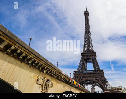 Eiffelturm gegen den blauen Himmel mit Wolken und eine Brücke über den Fluss Seine. Paris Frankreich. April 2019 Stockfoto