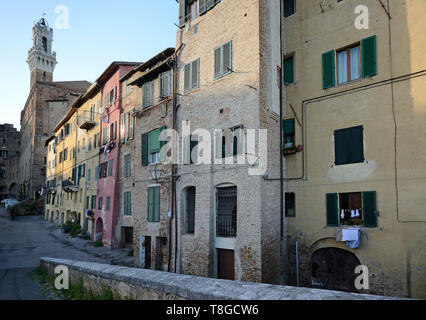 Typische Straße im historischen Zentrum von Siena mittelalterliche Stadt mit Torre del Mangia im Hintergrund Stockfoto