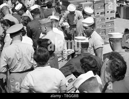 American sailor rauchen Zigarre mit Schnäppchenjäger bei United States open air Markt 1954 Stockfoto