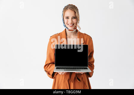 Portrait von eine wunderschöne blonde junge hübsche Frau tragen Seidenschal über weiße Wand Hintergrund angezeigt Display Laptop Computer isoliert posieren. Stockfoto