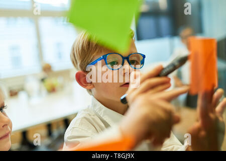 Art schreibt Ideen und Gedanken auf Haftnotizen im Brainstorming workshop Stockfoto