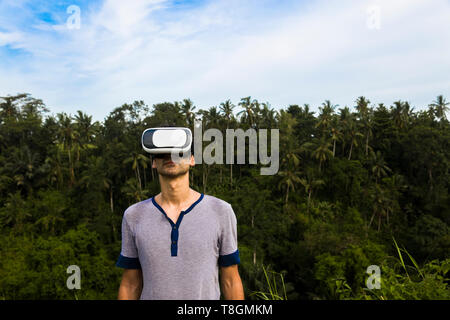 Junger Mann mit VR-Brille in der tropicalforest Stockfoto