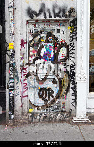 COLLAGE. Eine Tür auf Houston St. in Manhattan mit Graffiti, Sticker und Tagging. New York City. Stockfoto