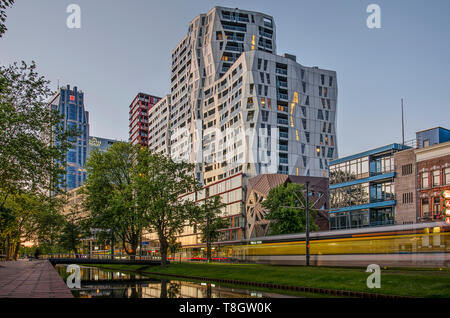 Rotterdam, Niederlande, 12. Mai 2019: Blick auf die grüne Bank der Westersingel Kanal kurz vor Einbruch der Dunkelheit mit einem vorbeifahrenden Straßenbahn und das Calypso ap Stockfoto