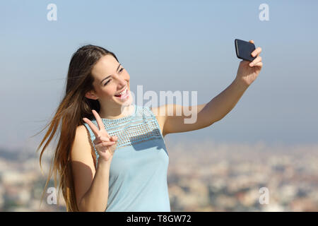 Happy tausendjährigen Mädchen unter selfies mit Smart Phone im Freien in einer Stadt Stadtrand Stockfoto