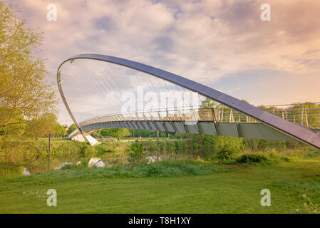 Die Millennium Bridge in New York. Ein modern gestaltetes steel Suspension Bridge mit einem gebogenen Bogen unterstützt einen Fußweg mit Kabel. Stockfoto