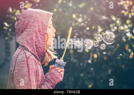 Junge im Garten bläst Seifenblasen Stockfoto