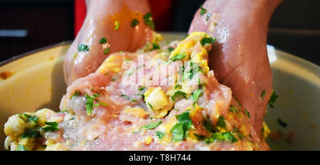 Frau Hände bereiten miced frisches Fleisch für die fleischbällchen. Manuell mischen das Fleisch mit Eiern, Petersilie und Knoblauch. Stockfoto