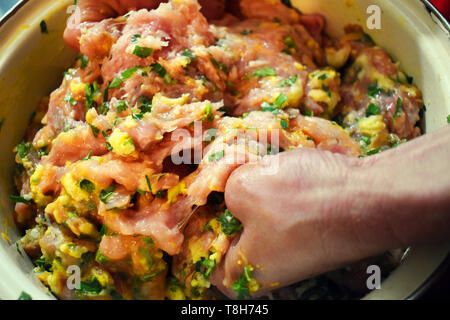 Frau Hände bereiten miced frisches Fleisch für die fleischbällchen. Manuell mischen das Fleisch mit Eiern, Petersilie und Knoblauch. Stockfoto