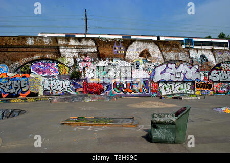 Ein verlassener Mile End Skatepark im Osten Londons, komplett mit Graffiti und einem altmodischen bequemen Sessel, der abgeladen wurde. Stockfoto