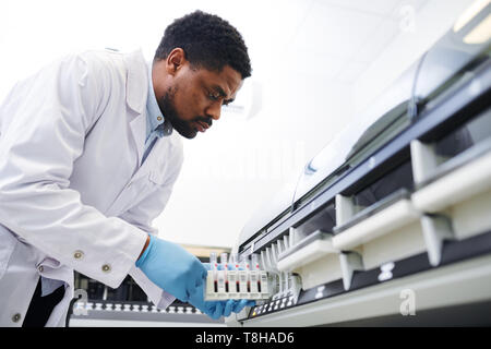 Schwarze Arzt arbeiten mit pharmazeutischen Maschine Stockfoto