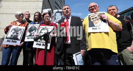 John Teggart (Mitte), dessen Vater Danny tot in Ballymurphy erschossen wurde, Medien von außerhalb von Belfast Untersuchungsrichter Gericht spricht, neben anderen trauernden Angehörigen. Stockfoto