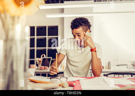 Fashion Stylist spricht von seinem Telefon in einem Studio. Stockfoto