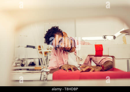 Junger Mann das Nähen eines Kleides in einem Studio. Stockfoto