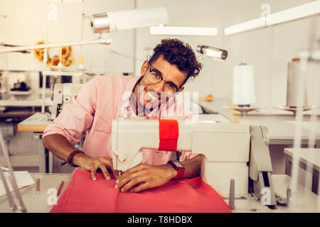 Schöne Designer nähen ein Kleid mit einer Nähmaschine. Stockfoto