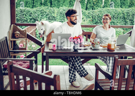 Gerne Freiberufler Sharing ein Lachen beim Frühstück im Garten Stockfoto