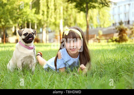 Süße kleine Mädchen mit Mops Hund im Park im Sommer Tag Stockfoto