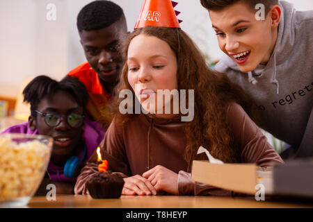 Mädchen bläst Kerze und gleichzeitig einen Wunsch feiert Geburtstag Stockfoto