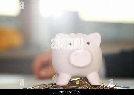 Hand Geschäftsmann, pin Geld in Schwein Stockfoto