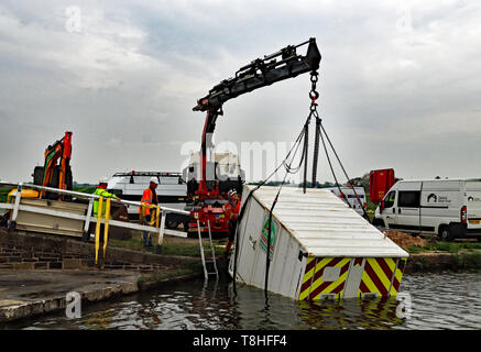 Eine Wohlfahrt Behälter wird aus dem Leeds und Liverpool Canal in der Nähe von haskayne nach einem Akt von Vandalismus mit JCB über Nacht am 23. April 2019 aufgehoben Stockfoto