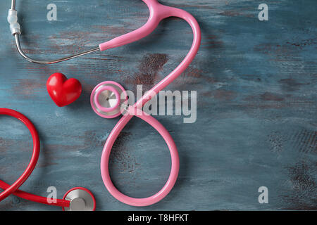 Medizinische Stethoskope und roten Herzen auf Holz- Hintergrund. Kardiologie Konzept Stockfoto