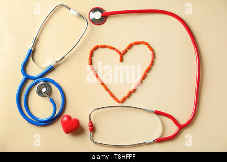 Medizinische Stethoskope, Pillen und roten Herzen auf hellen Hintergrund. Kardiologie Konzept Stockfoto