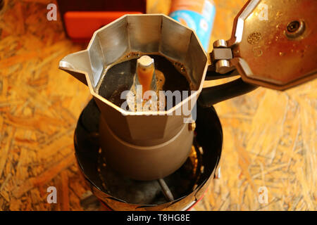 Kochendes Wasser durch den gemahlenen Kaffee in den unteren Sieb erstellen einen Schuß von aromatischen Espresso in den Topf läuft Stockfoto