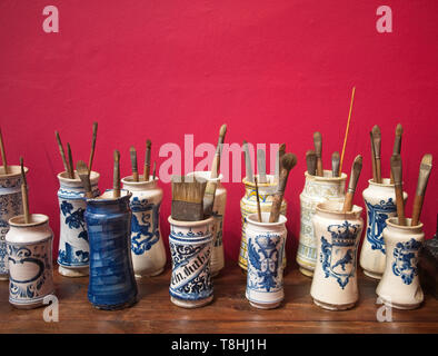 Pinsel in traditionellen spanischen Porzellan Vasen gegen rote Wand bei Sorolla Museum, Madrid, Spanien. Stockfoto