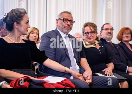 13. Mai 2019, Bayern, München: William Hartwig-Almer, ehemaliger Profifußballer (M), zeigt sich zwischen Irina Wanka, Schauspielerin (l) und Alexandra Gaßmann, Stadtrat der Landeshauptstadt München, in seiner Laudatio bei der Verleihung der Bayerischen Staatsmedaille für Soziale Dienstleistungen im Max-Joseph-Saal der Residenz. Hartwig-Almer ist die soziale-Medaille für sein Engagement im Kampf gegen Diskriminierung und Rassismus ausgezeichnet. Foto: Matthias Balk/dpa Stockfoto
