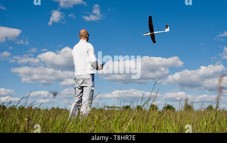 Hannover, Deutschland. 13. Mai, 2019. Ein Mann am Kronsberg ermöglicht ein Modell, einen Gleitschirm fliegen. Credit: Julian Stratenschulte/dpa/Alamy leben Nachrichten Stockfoto